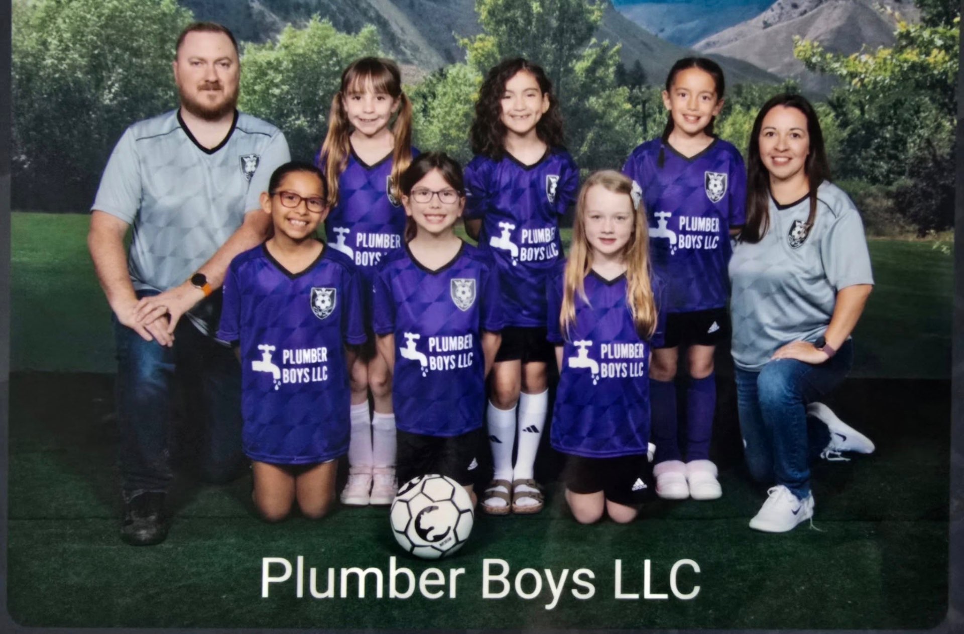 Plumber Boys LLC sponsored youth soccer team in purple jerseys with coaches